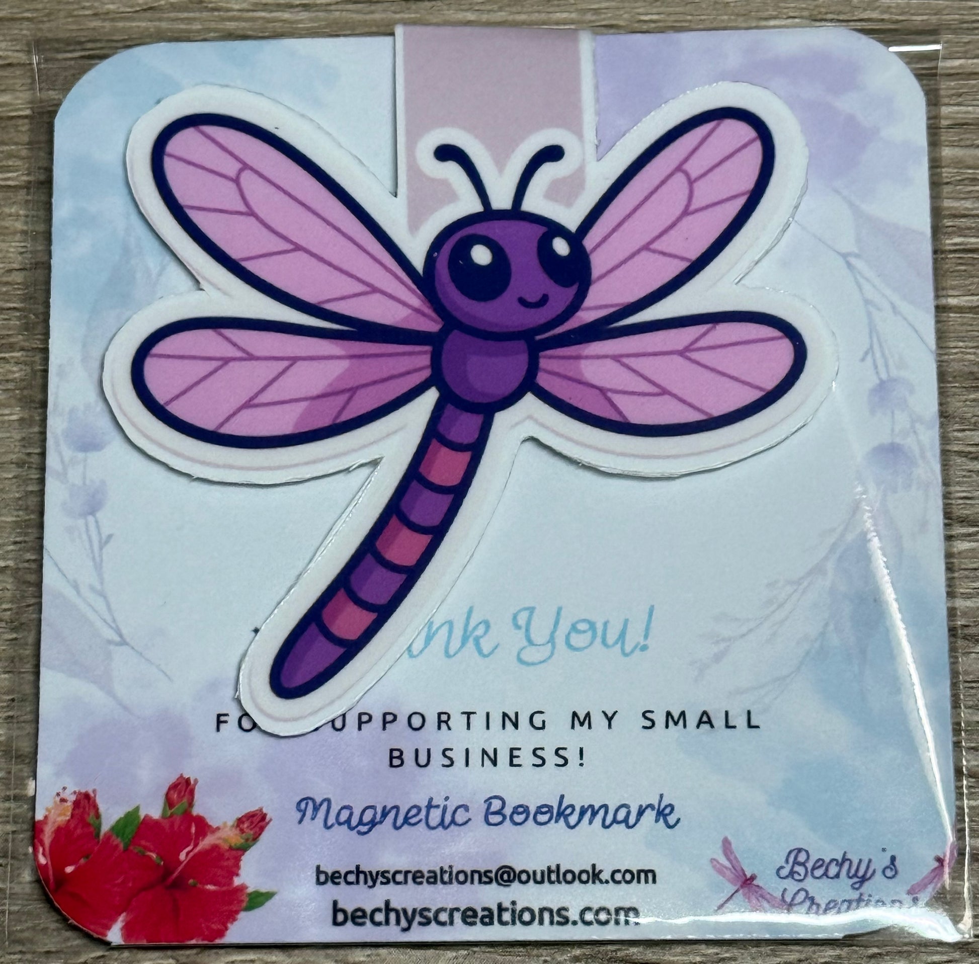 This is a magnetic bookmark with a purple and pink dragonfly design.